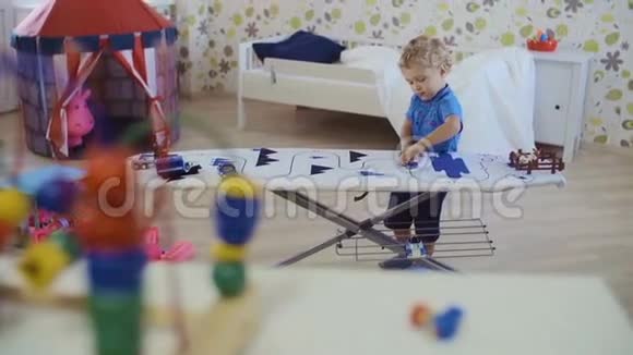 小卷发男孩在房间里玩玩具视频的预览图