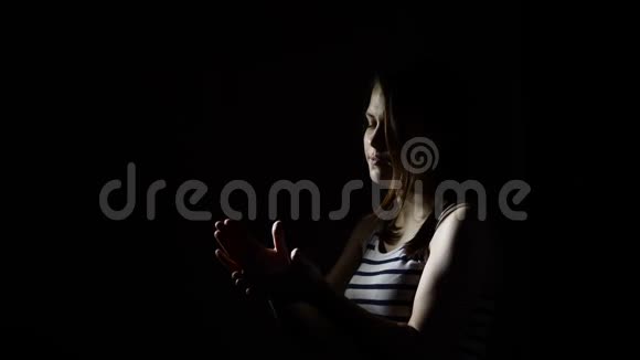 少年女孩在黑暗中举起慢动作拍手视频的预览图