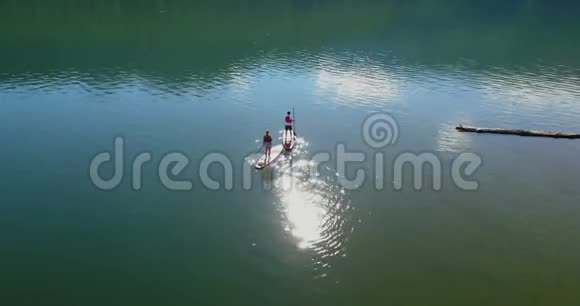 一对夫妇站在4k河边的桨板上视频的预览图