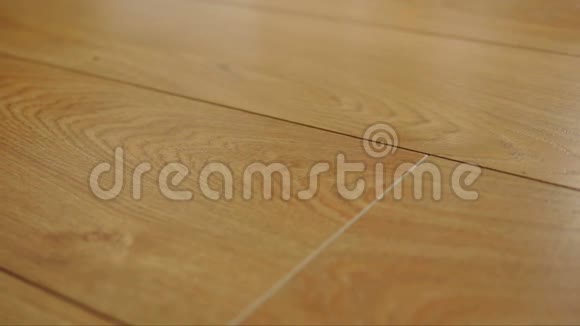 摄像机沿着地板移动上面覆盖着一层棕色木质纹理的层叠拼花视频的预览图