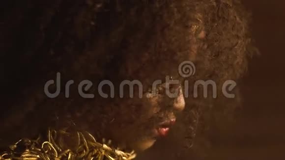 大特写非洲裔美国女性模特金色光泽的妆容和大红色的嘴唇面子艺术创意时尚概念视频的预览图