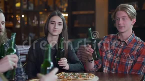 朋友们在餐馆里等披萨的时候喝啤酒和聊天慢动作视频的预览图