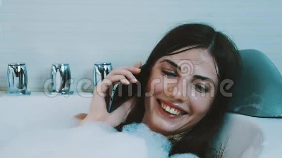 布鲁内特女孩正在洗满泡沫的澡打电话来别紧张笑吧微笑视频的预览图