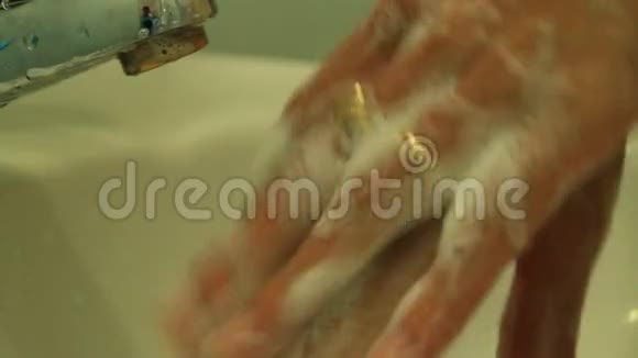 女孩在水龙头下用肥皂洗手视频的预览图