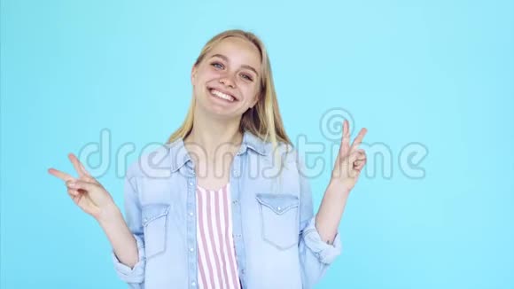 幸福的年轻女士站在蓝色背景上孤立的形象视频的预览图