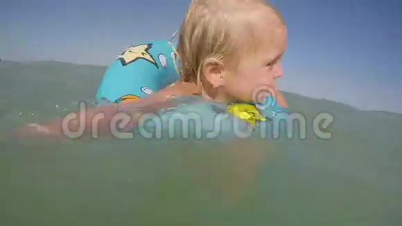一个金发碧眼的小女孩在水中嬉戏视频的预览图