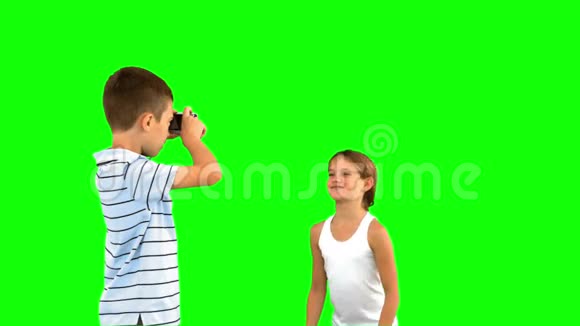 哥哥拍妹妹跳在绿色屏幕上的照片视频的预览图