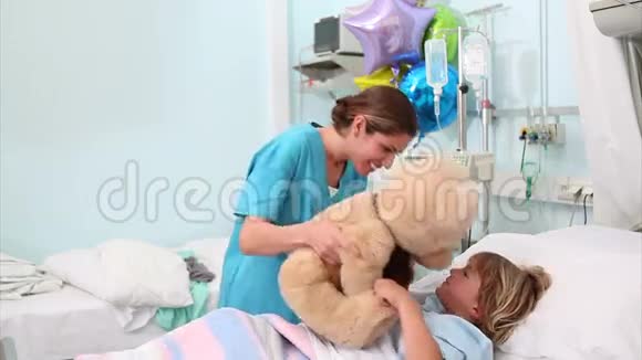 微笑护士给孩子看玩具熊视频的预览图