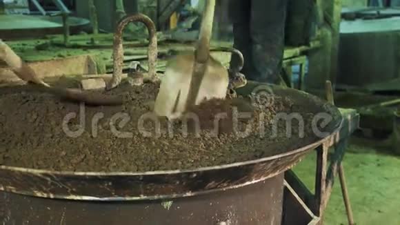 两名工人用铁锹在振动机金属釜上铺水泥视频的预览图