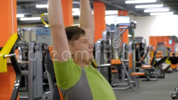 一个人坐在健身室里用哑铃做长凳按压视频的预览图