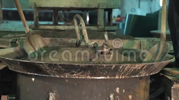 两名工人用铁锹在振动机金属碗上铺混凝土视频的预览图
