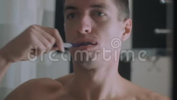 年轻人在浴室刷牙因为牙疼而停下来视频的预览图