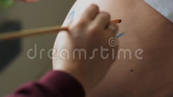 小孕妇肚子上写字男孩慢动作视频的预览图