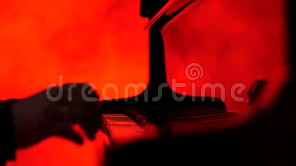 一个钢琴家弹钢琴然后关闭他红色背景视频的预览图