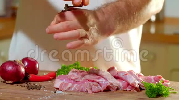 木制木板上的一块猪用盐擦的雄手高清视频剪辑那个人用胡椒粉蘸了一块猪肉视频的预览图