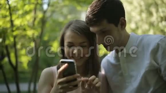 快乐的女孩和她男朋友的绿树照片特写镜头视频的预览图