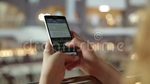 女人用智能手机在购物中心写短信视频的预览图