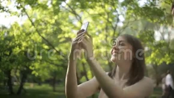 快乐的女孩拍绿树视频的预览图