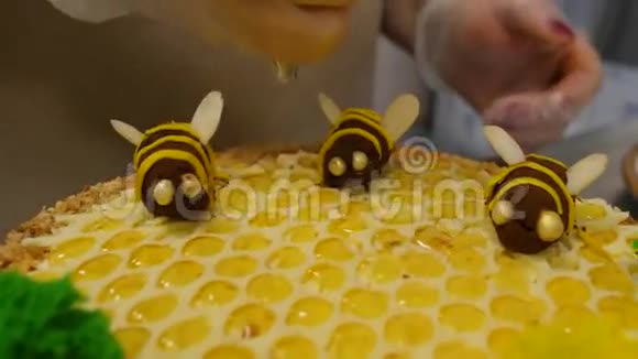 合上手在蛋糕上浇蜂蜜在蛋糕上撒蜂蜜视频的预览图
