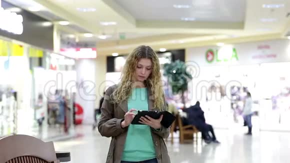 带平板电脑的年轻女子在购物中心遇到了男人视频的预览图