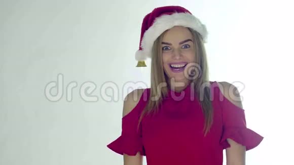戴着红色圣诞帽的圣诞老人微笑着手里拿着一张床单幸福的笑容被孤立在白色的背景上视频的预览图