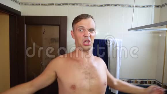 一个男人在浴室里的镜子旁边唱歌跳舞在早晨的厕所里4k慢动作视频的预览图