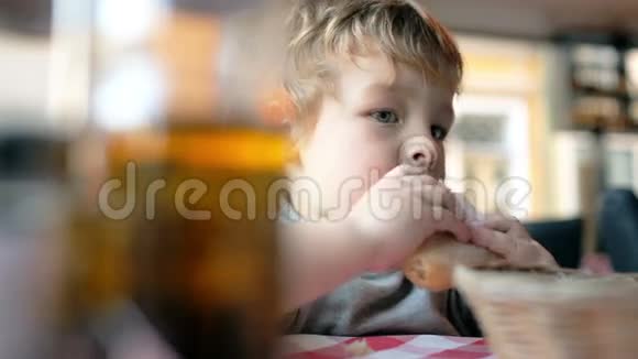 可爱的男孩在咖啡馆里吃面包视频的预览图