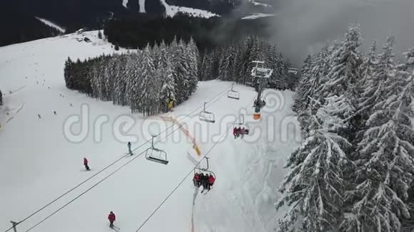 滑雪场森林里的滑雪缆车将人们带到山顶视频的预览图