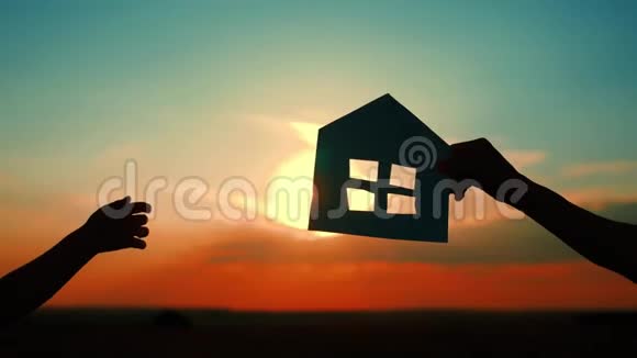 剪影把一家人和纸房放在天空日落的背景下视频的预览图