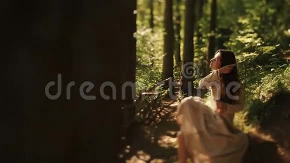 温柔的少女赤脚坐在喀尔巴阡山的树林里梳辫子视频的预览图