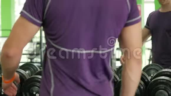 强壮的运动员带着沉重的哑铃在健身房积极锻炼健身视频的预览图