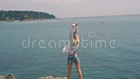 年轻漂亮的时装模特女子在海滩上举起双臂视频的预览图