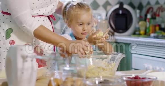 可爱的小女孩揉捏烘焙原料视频的预览图