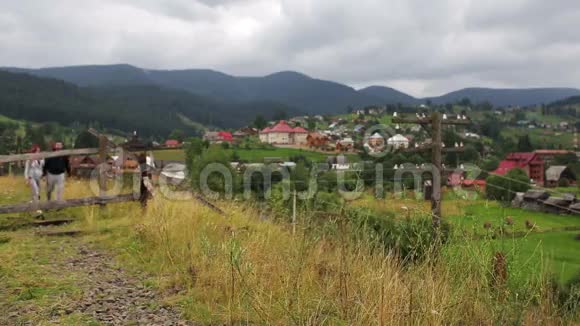 一对美丽的情侣一起走在山上的铁路上视频的预览图