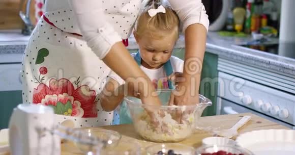 可爱的小女孩揉捏烘焙原料视频的预览图