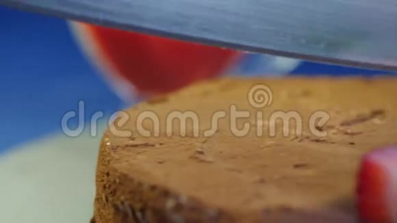 女性切巧克力蛋糕草莓在木桌上深蓝色背景玻璃巧克力蛋糕切片视频的预览图