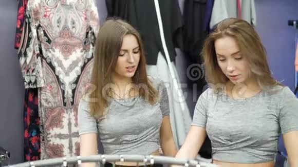 两个漂亮的女孩在时尚的精品店里看着裤子视频的预览图