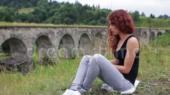 坐在山上老高架桥附近跳舞的女孩视频的预览图