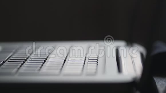 现代笔记本电脑键盘上的手轴手指键入文本关门视频的预览图