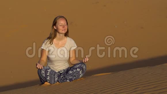 穿着莲花姿态的少女在红色的沙漠中迎接黎明视频的预览图