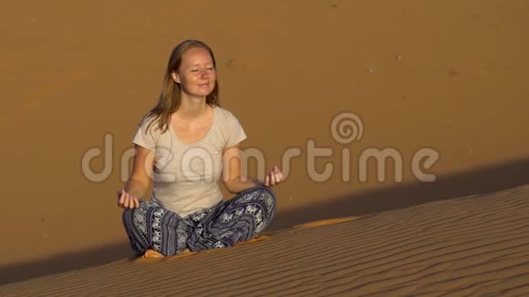 穿着莲花姿态的少女在红色的沙漠中迎接黎明视频的预览图