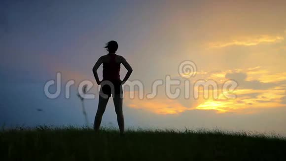运动员在一个女孩的日落剪影上做运动视频的预览图