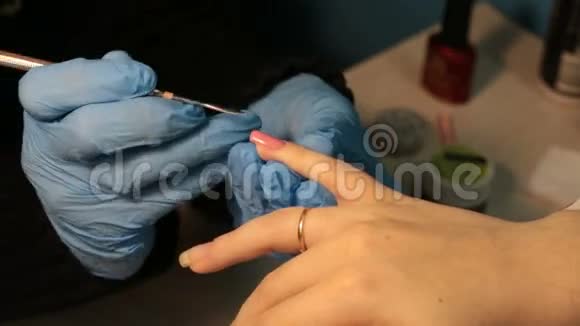 女人修指甲在指甲上涂上粉红色指甲油视频的预览图