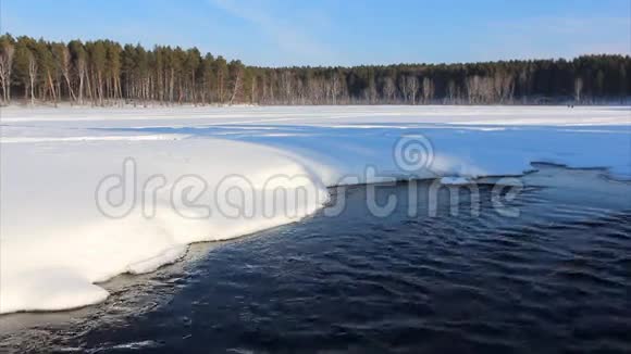 从湖中流出的水在俄罗斯西伯利亚的日落雪中流淌视频的预览图