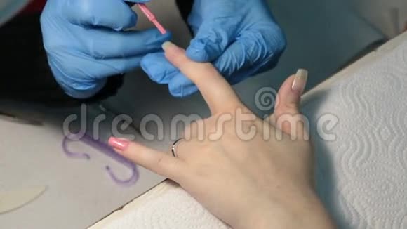 女人修指甲在指甲上涂上粉红色指甲油视频的预览图
