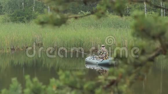 一个渔夫坐在船上拿着鱼竿等着鱼清晨湖面上的雾视频的预览图
