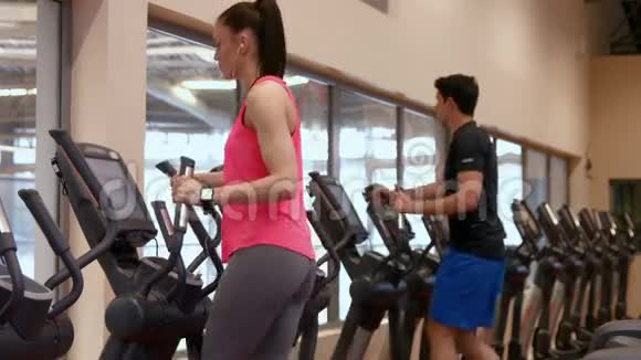 在健身房使用交叉训练器的男人和女人视频的预览图