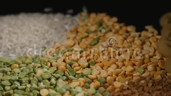 谷物豌豆扁豆大米荞麦面食混合在黑色背景上旋转视频的预览图