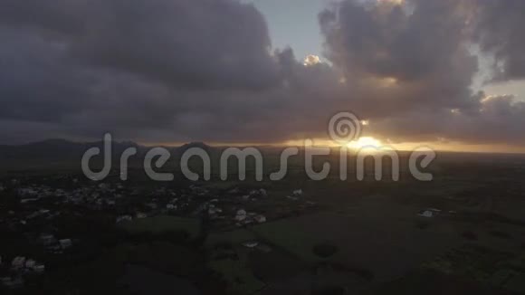 鸟瞰毛里求斯岛森林农场田野和山丘映衬日落的天空和粉红色的云彩视频的预览图