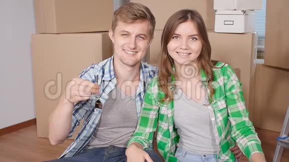 年轻的已婚夫妇带着盒子拿着平钥匙视频的预览图